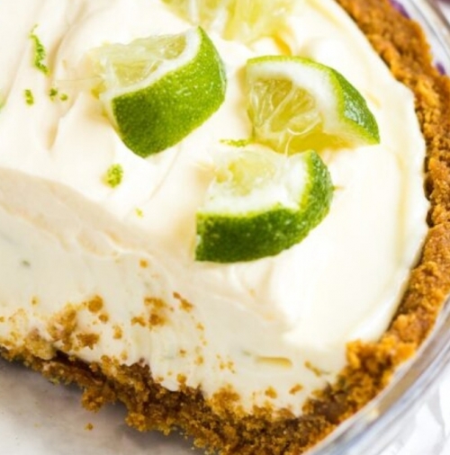 Key-lime pie with whipped cream, lime slices, and graham cracker crust.