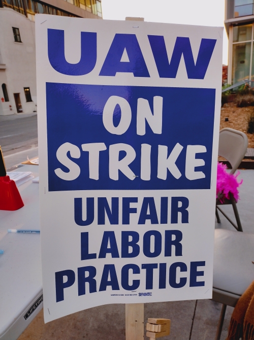 A strike sign that reads "UAW on strike. Unfair labor practice."